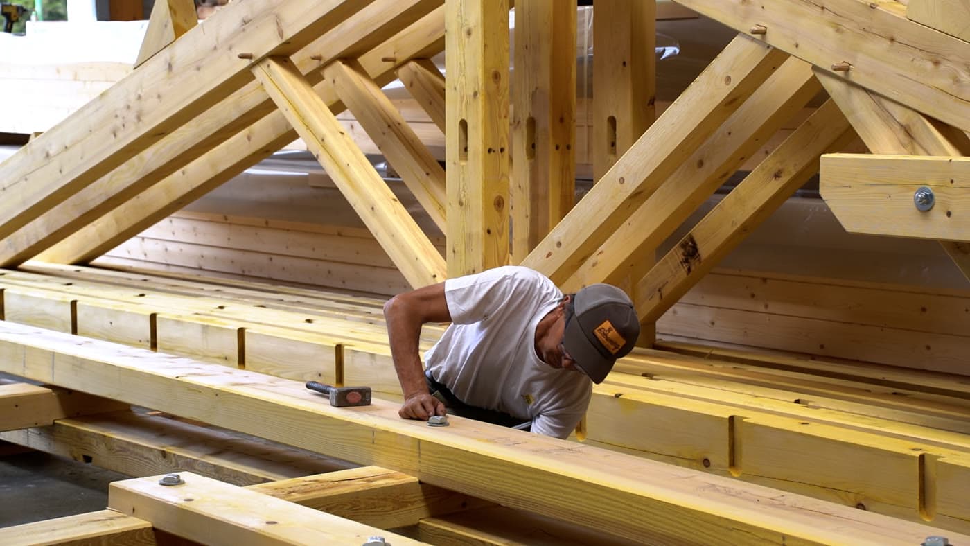 Assemblage d'une charpente bois sur mesure dans l'atelier d'Extrat