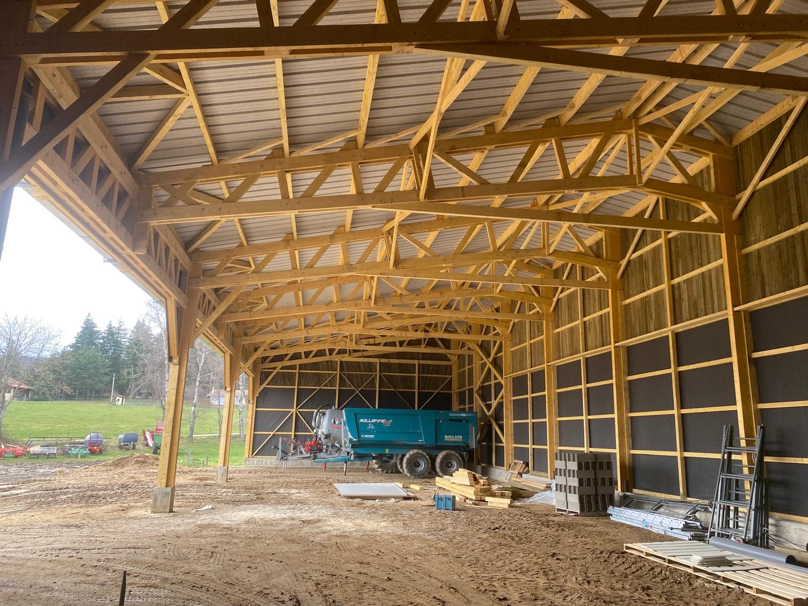 Intérieur d'un grand hangar agricole en charpente bois
