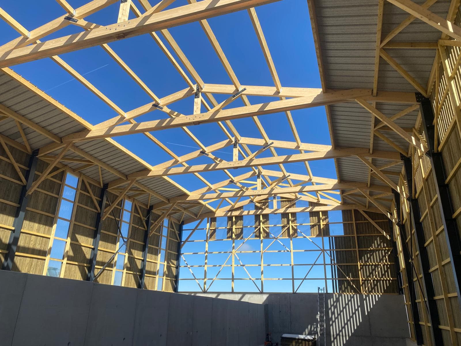 Charpente bois vue de l'intérieur d'un grand hangar agricole