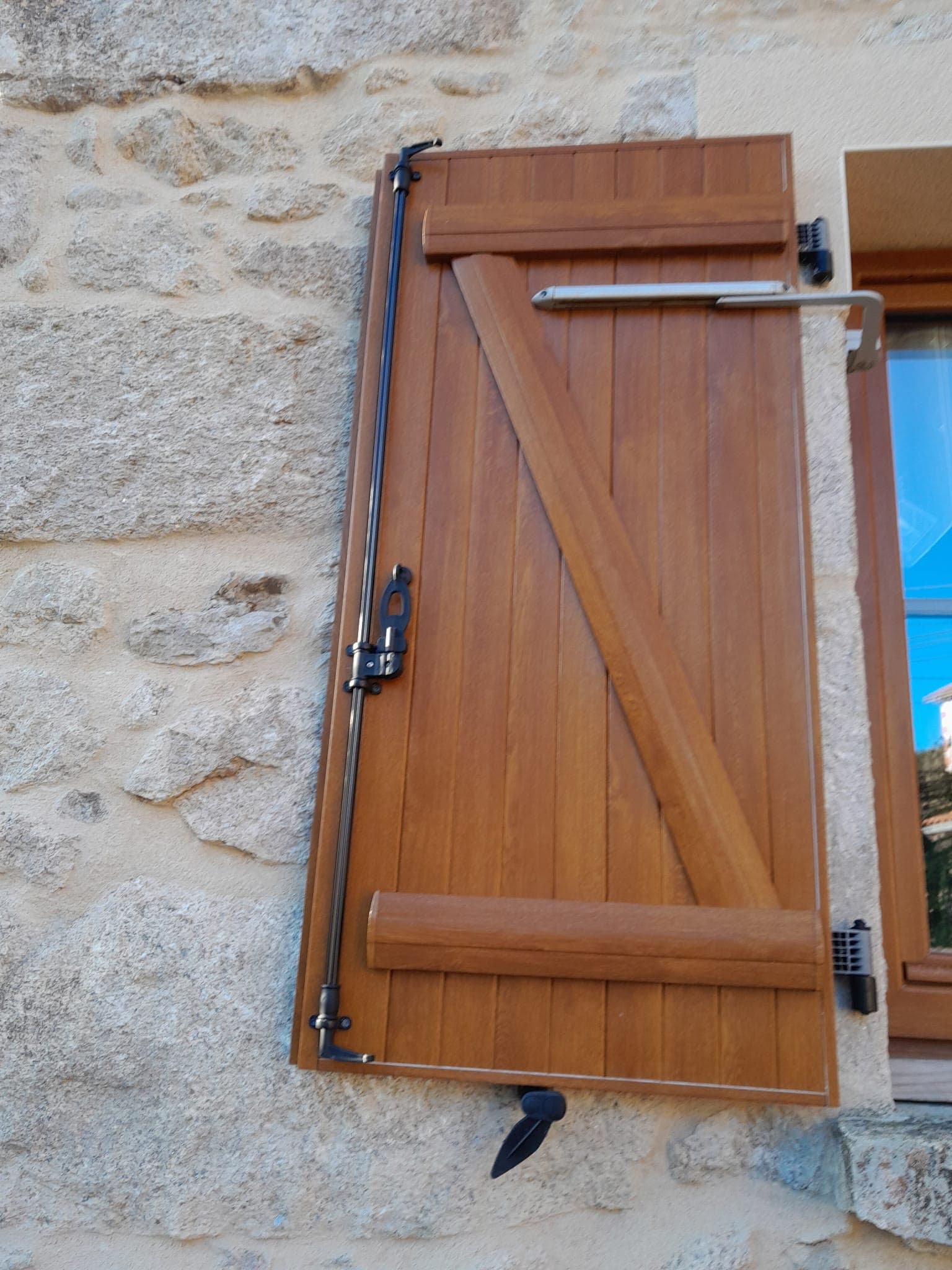 Volet battant en bois sur un mur en pierre