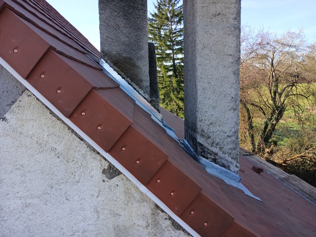 Solin en zinc autour de souches de cheminée sur une toiture en tuiles, Beylot
